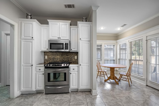 406 Parliament St, Little Rock, AR 72211 - kitchen with appliances with stainless steel finishes, white cabinetry, decorative backsplash, and ornamental molding