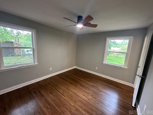 706 Scott St, Sheridan, AR 72150 - empty room with healthy amount of natural light, baseboards, a ceiling fan, and dark wood-style flooring