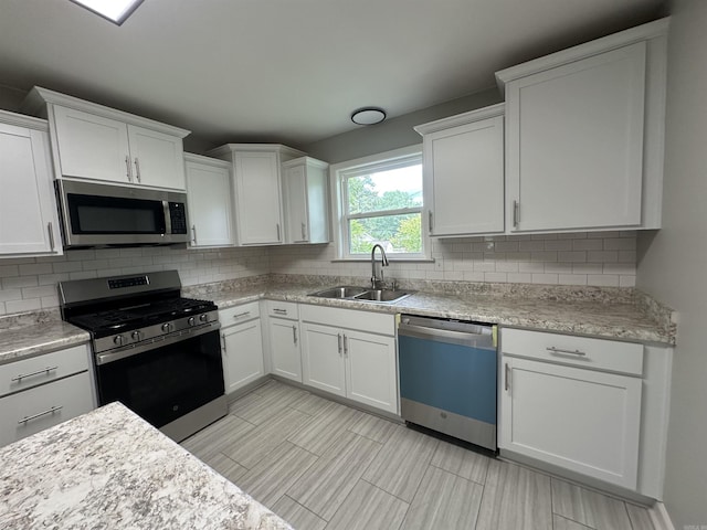 706 Scott St, Sheridan, AR 72150 - kitchen with stainless steel appliances, a sink, light countertops, decorative backsplash, and white cabinets