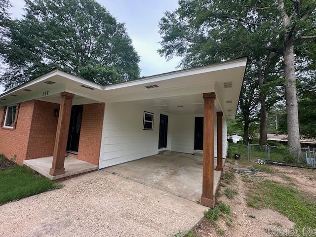 706 Scott St, Sheridan, AR 72150 - view of front of home with driveway, brick siding, fence, and an attached carport