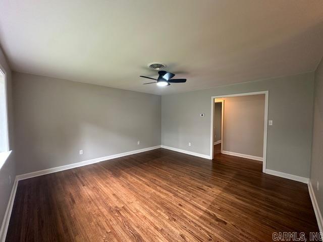 706 Scott St, Sheridan, AR 72150 - spare room featuring dark wood-type flooring, a ceiling fan, and baseboards