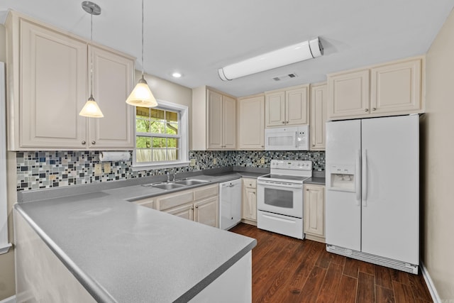 kitchen with white appliances, a sink, dark wood-style flooring, a peninsula, and hanging light fixtures