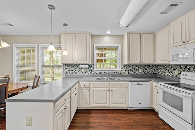 kitchen featuring white appliances, a sink, a peninsula, tasteful backsplash, and recessed lighting