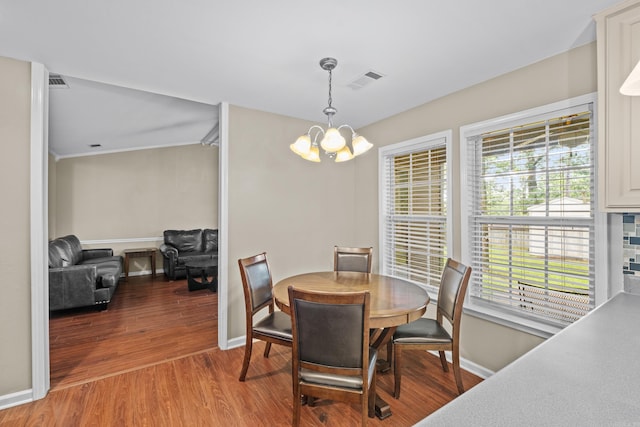 dining area with a chandelier, wood finished floors, baseboards, and healthy amount of natural light