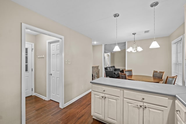 kitchen with dark wood-type flooring, a chandelier, baseboards, hanging light fixtures, and light countertops