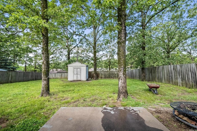 view of yard featuring a fire pit, a storage shed, and an outbuilding