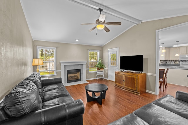 living room with wood finished floors, plenty of natural light, a ceiling fan, and crown molding
