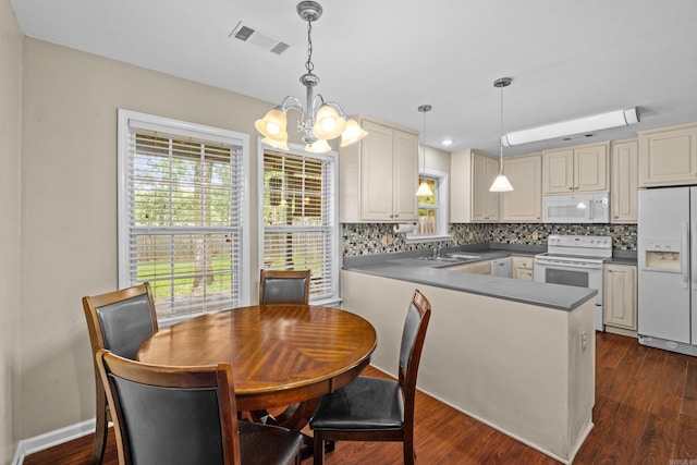 kitchen featuring white appliances, a chandelier, a sink, decorative backsplash, and a peninsula