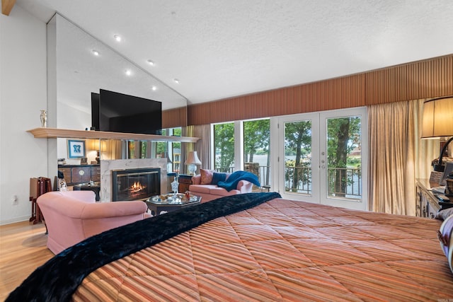 5000 Central Ave Unit 26-27, Hot Springs, AR 71913 - bedroom with vaulted ceiling, a glass covered fireplace, a textured ceiling, wood finished floors, and baseboards