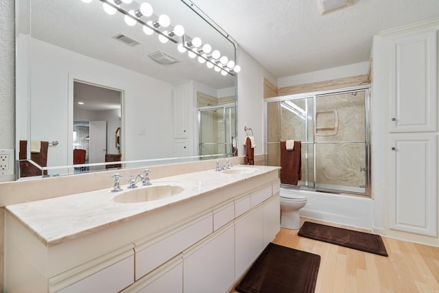 5000 Central Ave Unit 26-27, Hot Springs, AR 71913 - full bath featuring wood finished floors, double vanity, a textured ceiling, combined bath / shower with glass door, and toilet