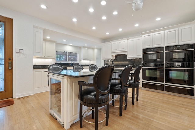 5000 Central Ave Unit 26-27, Hot Springs, AR 71913 - kitchen featuring beverage cooler, decorative backsplash, an island with sink, a kitchen breakfast bar, and recessed lighting