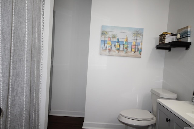 1108 N 14th St, Nashville, AR 71852 - full bathroom with toilet, vanity, wood finished floors, and baseboards