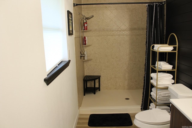 1108 N 14th St, Nashville, AR 71852 - bathroom with tiled shower, toilet, wood finished floors, vanity, and baseboards