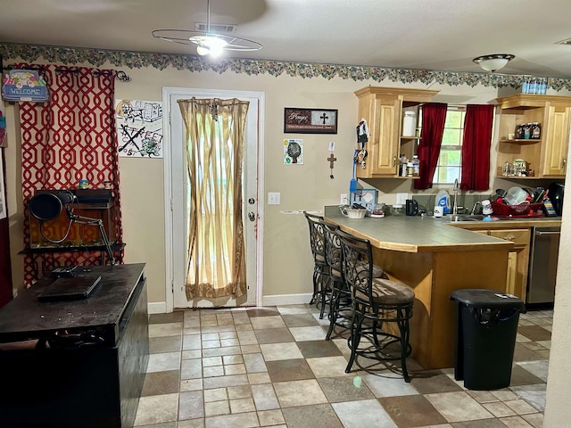 kitchen with ceiling fan, tile countertops, dishwasher, a breakfast bar, and open shelves