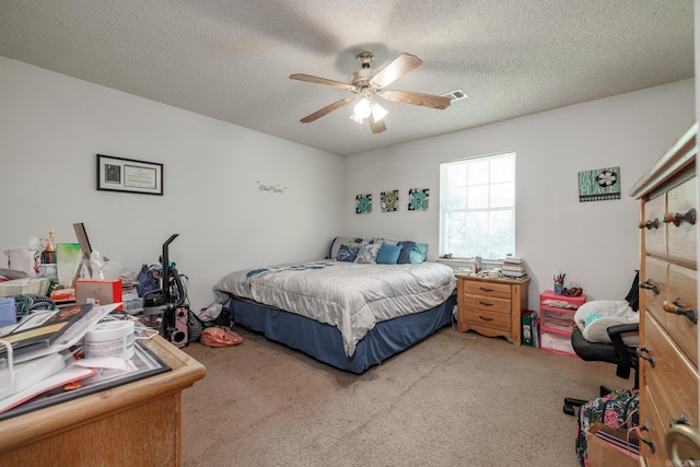 carpeted bedroom featuring a textured ceiling and ceiling fan