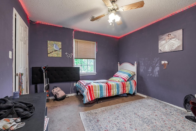 carpeted bedroom featuring a textured ceiling, a ceiling fan, and baseboards