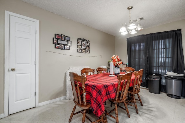 dining room featuring a chandelier, a textured ceiling, tile patterned floors, and baseboards