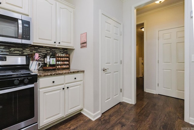 51 Waters Edge Dr, Little Rock, AR 72204 - kitchen with appliances with stainless steel finishes, tasteful backsplash, dark wood-style flooring, white cabinets, and baseboards