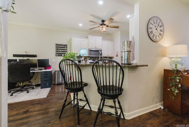 51 Waters Edge Dr, Little Rock, AR 72204 - kitchen featuring stainless steel microwave, a desk, a kitchen bar, white cabinets, and a ceiling fan