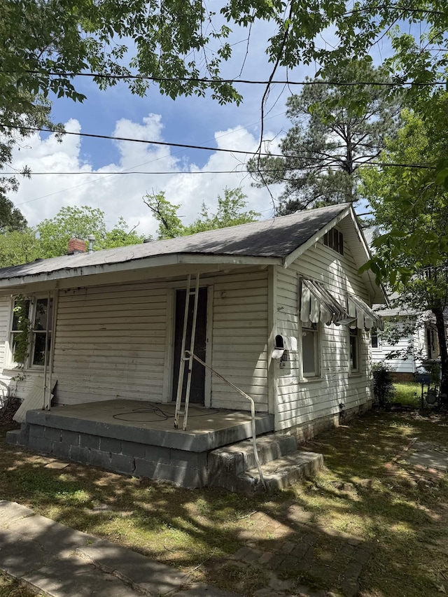 view of front facade featuring covered porch and a chimney