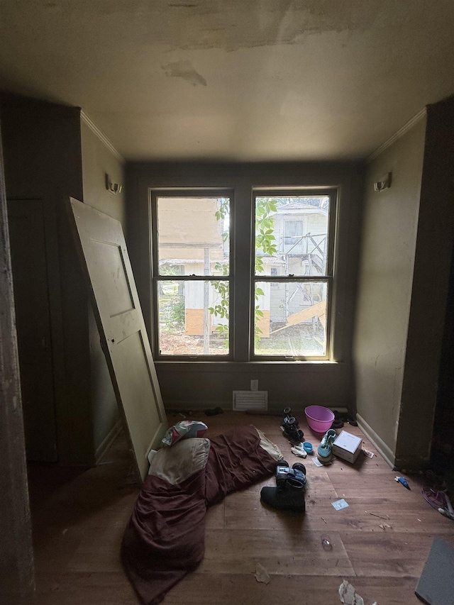 spare room with ornamental molding, wood finished floors, and baseboards