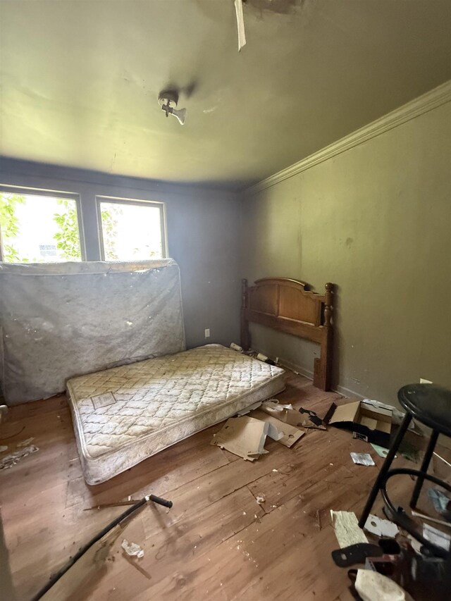 bedroom with ornamental molding and wood-type flooring
