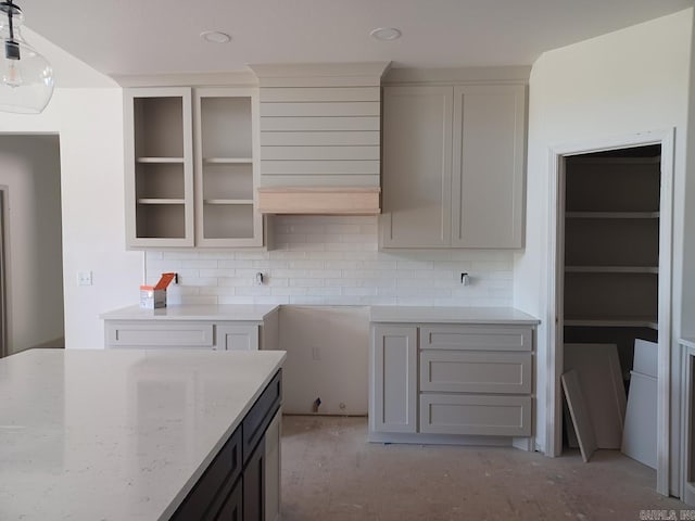 32 Propio Way, Hot Springs Village, AR 71909 - kitchen featuring light stone counters, backsplash, decorative light fixtures, glass insert cabinets, and gray cabinets