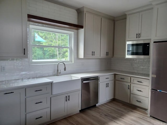 32 Propio Way, Hot Springs Village, AR 71909 - kitchen featuring stainless steel appliances, a sink, light countertops, tasteful backsplash, and light wood-style floors