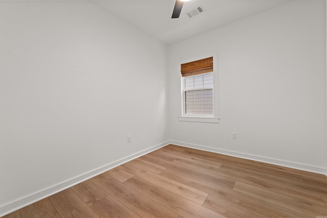 unfurnished room featuring ceiling fan, light wood-style floors, and baseboards
