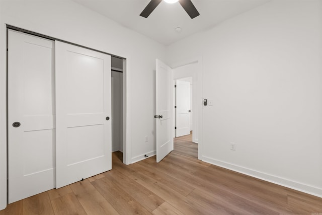 unfurnished bedroom featuring light wood-style floors, baseboards, a closet, and ceiling fan