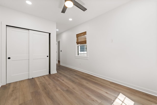 unfurnished bedroom featuring wood finished floors, a closet, baseboards, recessed lighting, and ceiling fan