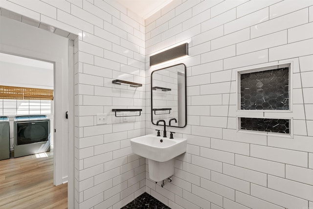 bathroom featuring wood finished floors and tile walls