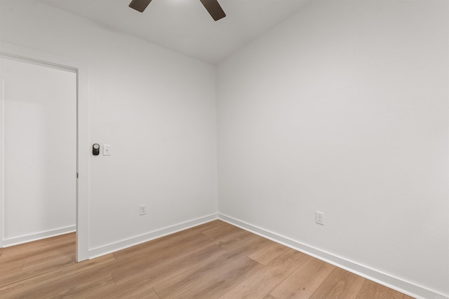 spare room featuring a ceiling fan, light wood-style floors, and baseboards