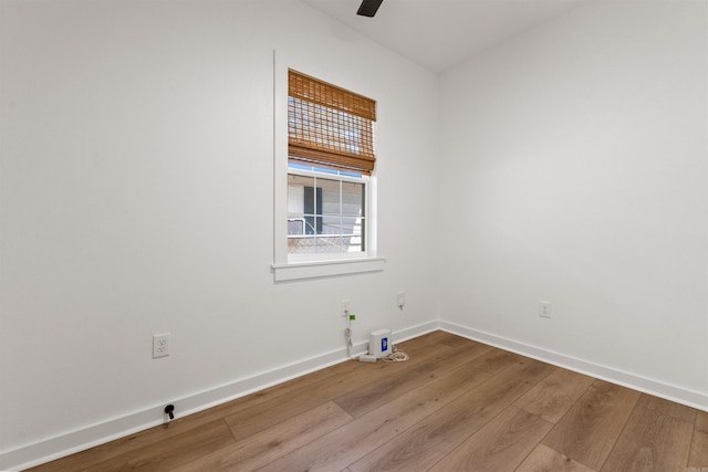 empty room featuring wood finished floors, baseboards, and ceiling fan