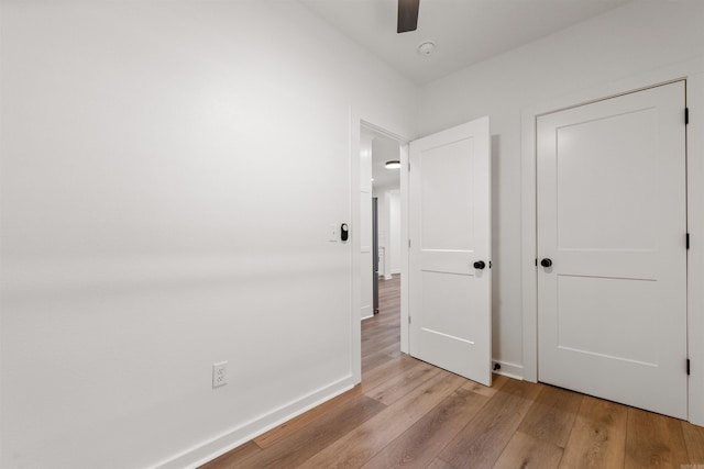 unfurnished bedroom featuring light wood-style floors, baseboards, and ceiling fan