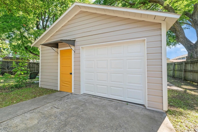 detached garage with fence and driveway