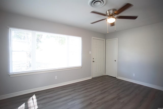 unfurnished room with dark wood-style flooring, ceiling fan, and baseboards