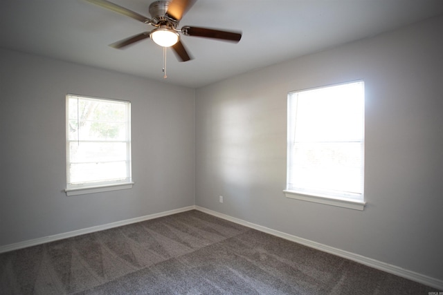 carpeted empty room with a ceiling fan and baseboards