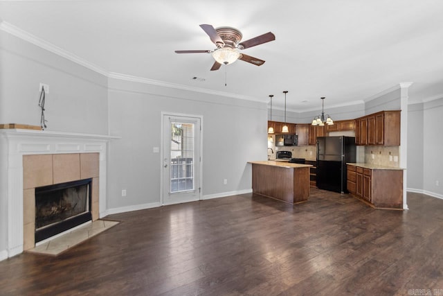 unfurnished living room with ceiling fan, dark wood-type flooring, ornamental molding, a chandelier, and baseboards