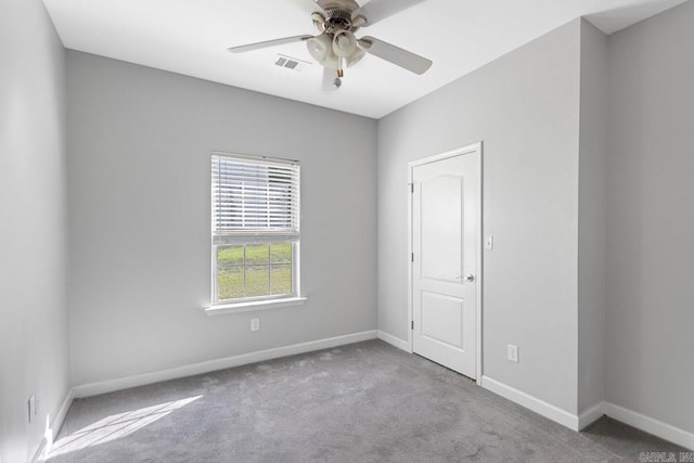 carpeted empty room with ceiling fan and baseboards