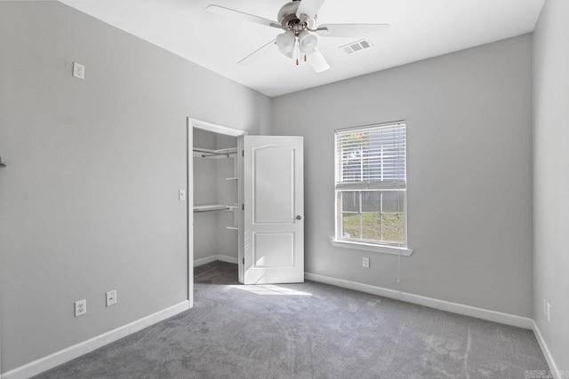 unfurnished bedroom featuring carpet, baseboards, a spacious closet, and a closet