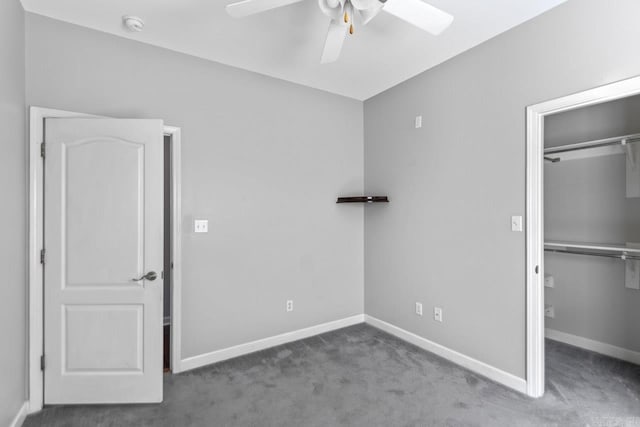 unfurnished bedroom featuring carpet floors, a spacious closet, a closet, and baseboards
