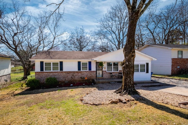ranch-style home featuring brick siding and a front yard