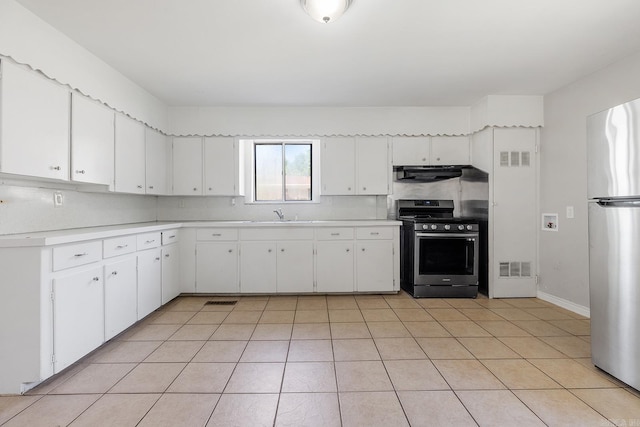 kitchen featuring appliances with stainless steel finishes, under cabinet range hood, light countertops, and light tile patterned floors