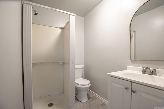 full bathroom with a stall shower, vanity, toilet, and wood finished floors