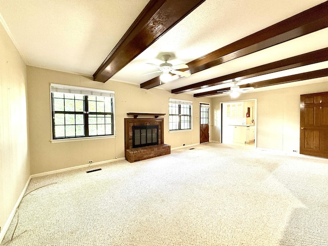 unfurnished living room featuring baseboards, ceiling fan, carpet, a brick fireplace, and beam ceiling