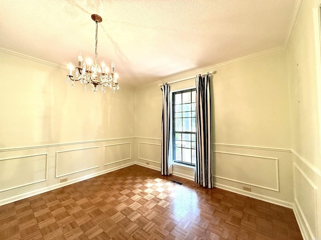 unfurnished room with a decorative wall, a chandelier, a textured ceiling, crown molding, and wainscoting