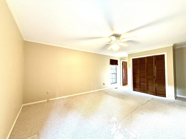 unfurnished bedroom with crown molding, a closet, baseboards, carpet, and a ceiling fan