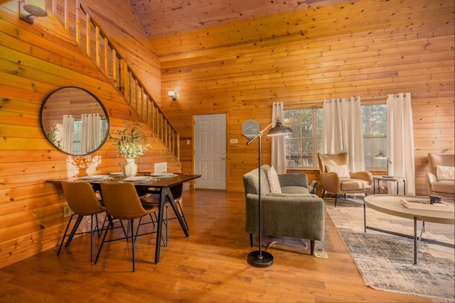 221 Skyline Dr, Greers Ferry, AR 72067 - dining room with wood walls, high vaulted ceiling, stairway, and wood finished floors