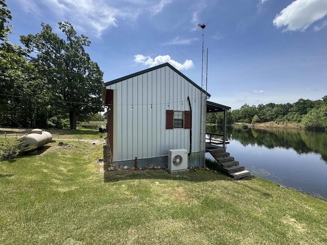view of outbuilding featuring a cooling unit and a water view